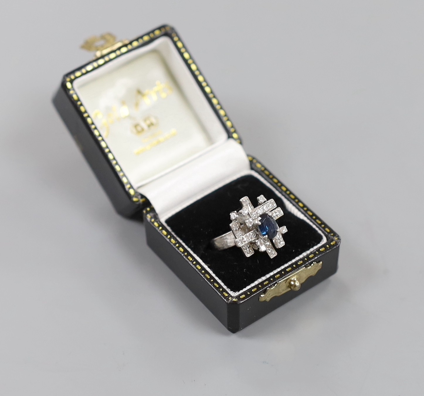 A modern 18k, sapphire and diamond cluster set dress ring, size K, gross weight 6 grams.